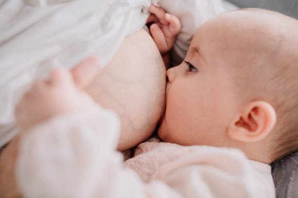 Lactancia materna la madre a su hija de bebé - foto de stock