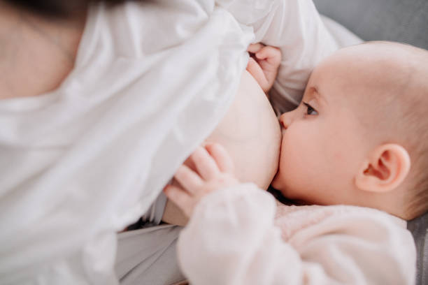 Lactancia materna la madre a su hija de bebé - foto de stock