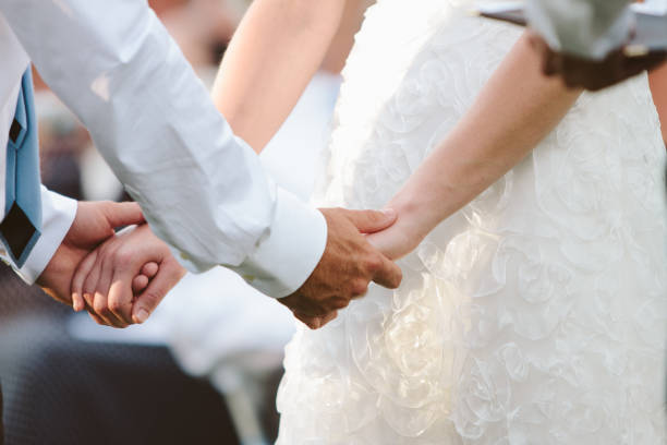 boda pareja explotación manos y poniendo el anillo en el dedo - foto de stock