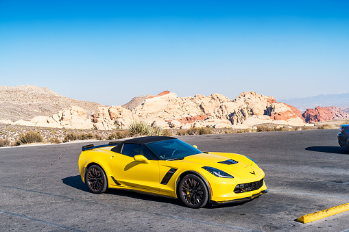 A yellow colored Chevrolet Corvette Z06 is parked in a parking lot in Red Rock Canyon National Recreation Area in Las Vegas Nevada USA on a sunny day.