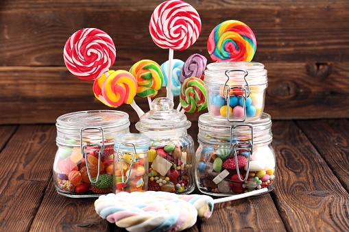 candies with jelly and sugar. colorful array of different childs sweets and treats in glass jar