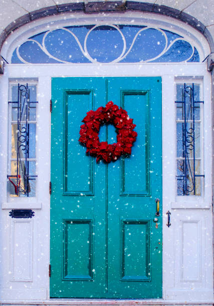 Snowy Christmas day Green and blue door with red wreath on a snowy Christmas day in Montreal, Quebec, Canada blue front door stock pictures, royalty-free photos & images