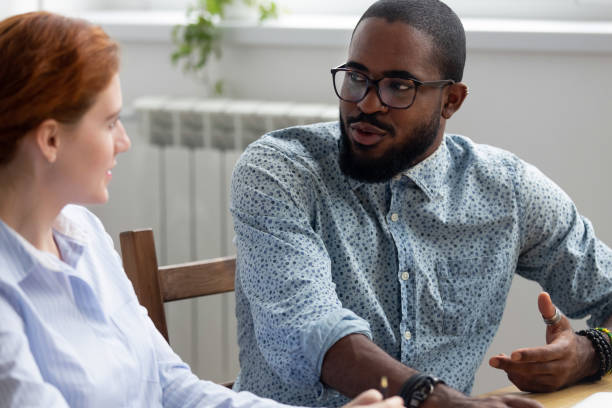 istock Diverse colleagues talking sitting together at office desk 1091526938