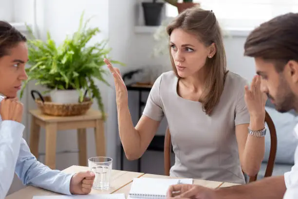 Dissatisfied team leader talking with colleagues discussing failure in work,  coworkers having different opinion sitting together in office arguing disputing blond colleague insists on her point of view