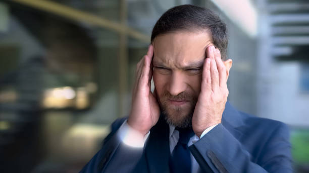 istock Man suffers from headache, massaging temples, migraine dizzy effect, close up 1091529772