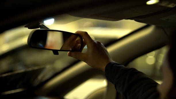 istock Man adjusting rear view mirror in car, driving license exam, visibility range 1091530452