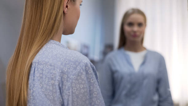 istock Upset female in pajamas looking in mirror, suffering insomnia, statistic 1091533688