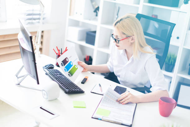 istock A young girl working in the office with a computer and documents. 1091534194