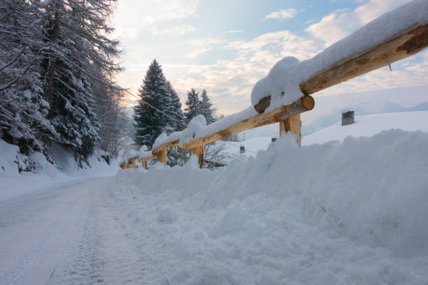 route recouverte de neige va au soleil - footpath european alps fence woods photos et images de collection