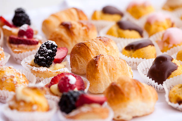 A vibrant collection of assorted pastries is presented on a tray. These sweet treats include delicate cookies, creamy confections, and flaky delights, showcasing intricate designs.