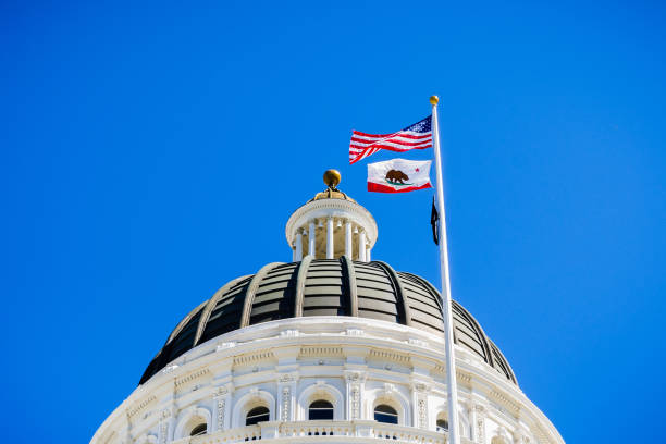 The dome of the California State Capitol, Sacramento April 14, 2018 Sacramento / CA / USA - The US and the California state flag waving in the wind in front of the dome of the California State Capitol mandate photos stock pictures, royalty-free photos & images