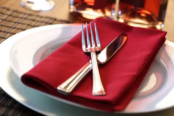 Elegant table setting with fork, knife and red napkin