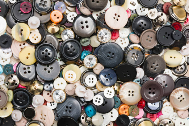 un sacco di bottoni da cucire colorati di diversi colori di metallo e plastica su tessuto naturale leggero di lino - plastic hole heap close up foto e immagini stock
