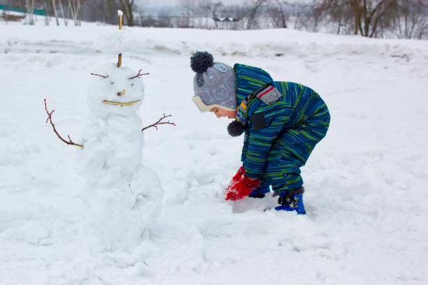 istock A four-year-old child, a boy,  sculpts a snowman. 1091565462
