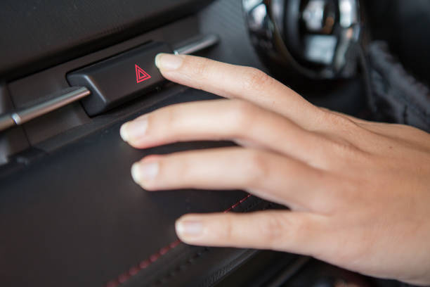 車で緊急ライト ボタンを押す女性手 - fog light switch ストックフォトと画像
