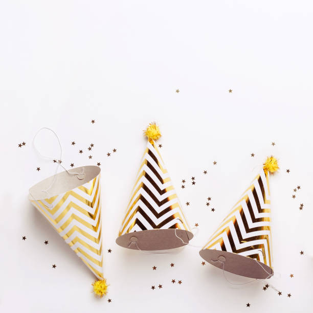 istock Three Striped golden cones hats and confetti on white background. Party concept 1091583666