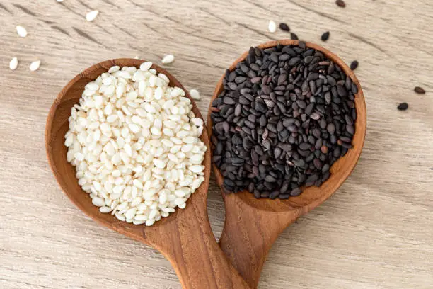 Photo of organic Black and White sesame seeds in a wooden spoon ,healthy food for reductions in both systolic and diastolic blood pressure