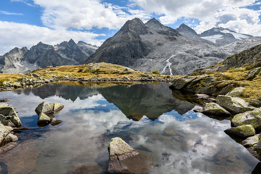 Reflection of the mountains Lobbia Bassa (2,903 m), Lobbia di Mezzo (3,036 m) and Lobbia Alta (3,196 m). It is located in the Adamello Brenta Nature Park (European Alps, Italy).