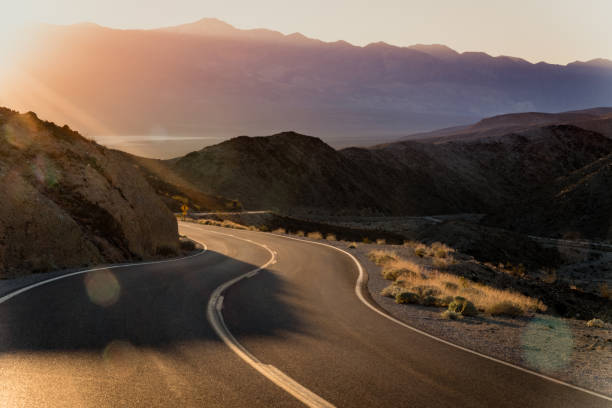 Highway at sunrise, going into Death Valley National Park stock photo