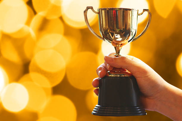 istock Winner hold trophy with background abstract night bokeh light 1091596856