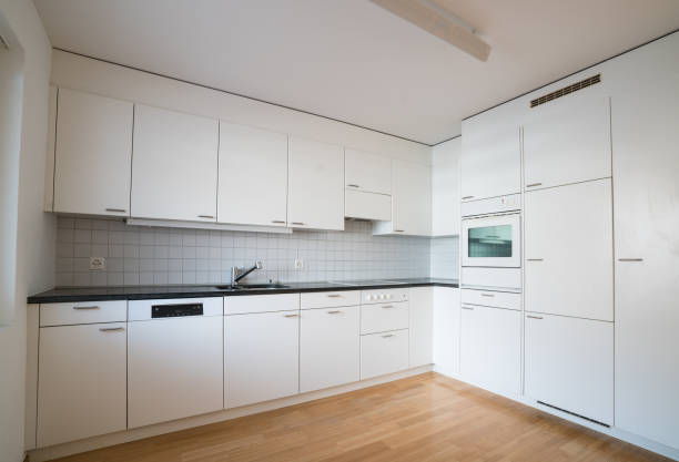 istock modern bright kitchen in an empty refurbished apartment with black granite work surface and wooden parquet floor 1091613132