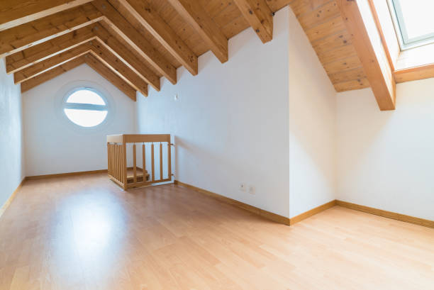 sottotetto vuoto spazioso e luminoso in un appartamento ristrutturato con pavimento in parquet in legno e pareti bianche e tetto a timpano in legno - inhabit foto e immagini stock