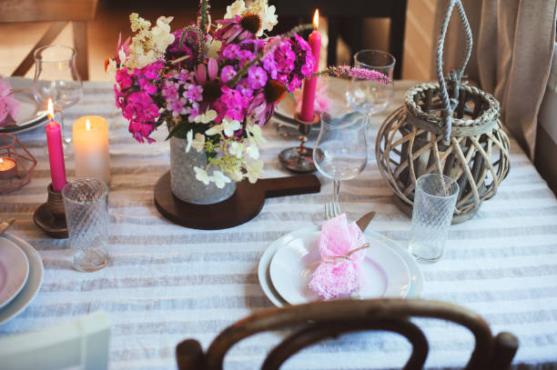 istock summer cottage kitchen decorated for festive dinner. Romantic table setting with candles and flowers in rustic style. 1091615962