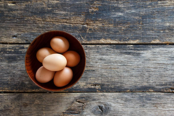 istock eggs in a wooden bowl on old wooden table top view 1091618930