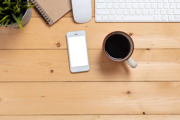 istock close up smartphone with coffee cup and  computer on wooden table top view. 1091620566