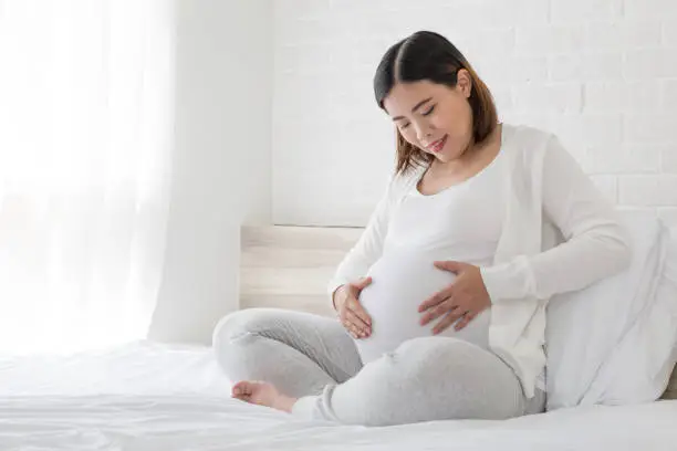 Photo of Asian pregnant women happy during pregnancy in the bedroom, Happiness and feel joyful as emotional well affect to baby neurological and psychological development