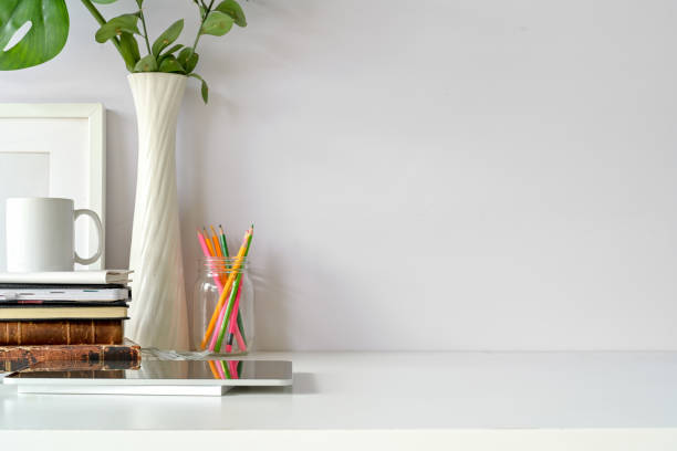 istock Front view of workplace, copy space, tablet, mockup poster on loft workspace white table. 1091626958