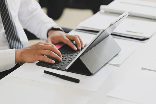 istock Business man working on tablet computer on white desk in office 1091627070