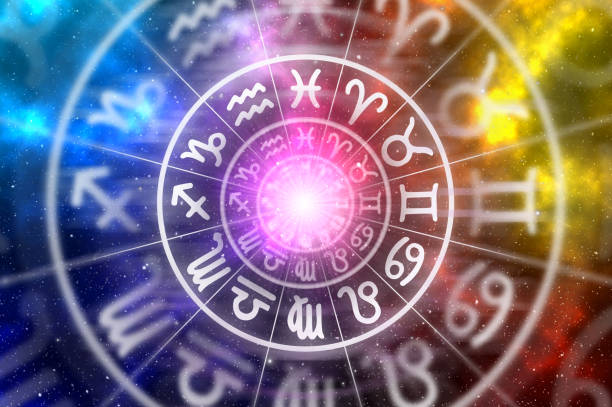 Zodiac signs inside of horoscope circle on universe background stock photo