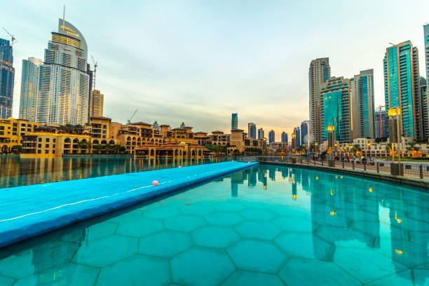 Dubai, UAE - November 28, 2018: Downtown Dubai district. View of the singing fountains and the Arabian shopping center Souk Al Bahar.
