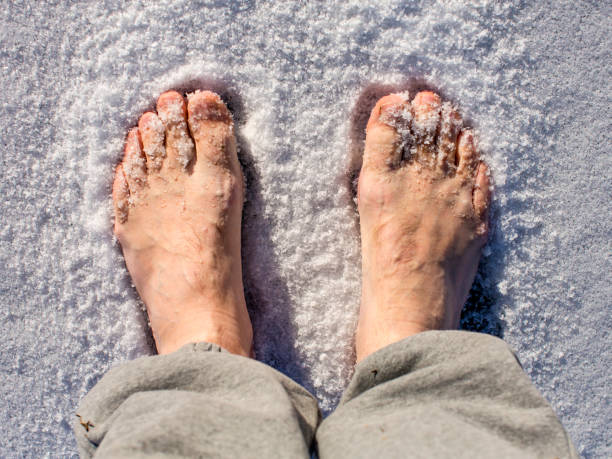 istock Men's bare feet in the snow in a sunny day. 1091636002
