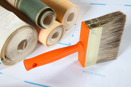 Orange paintbrush and wallpaper rolls