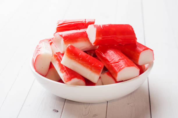 Salad crab sticks in a plate on a white table.