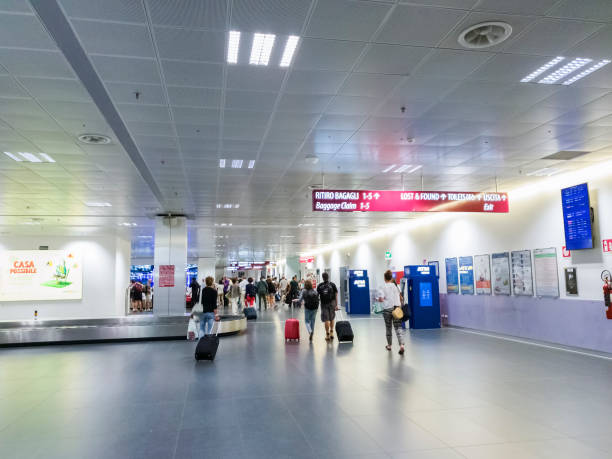 Unidentifiable travelers with luggage at arrivals area of Orio al Serio Caravaggio International airport. stock photo