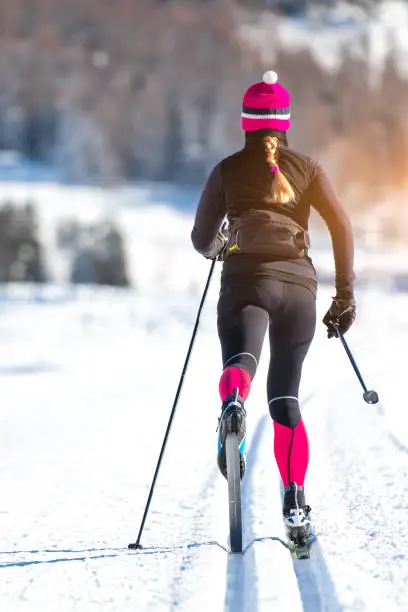 Cross-country skiing of a young athlete girl. Classical alternating technique.