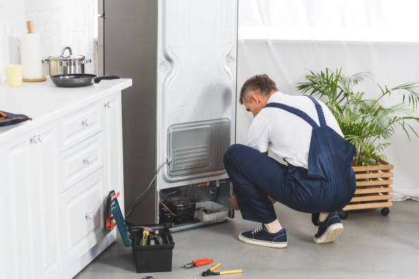 istock adult handyman repairing refrigerator at kitchen with tools on floor 1091652334