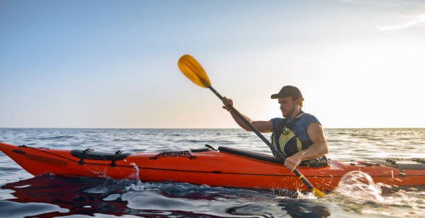 Kayaking concept with family of father mother and son swimming at sea at sunset time. Space for text