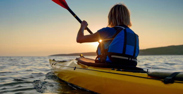 kayakiste aviron en mer - canoe kayak, jaune photos et images de collection