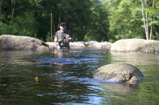 fly fisher fishing in moving water