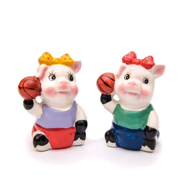 Two porcelain piggy with sports balls, isolate