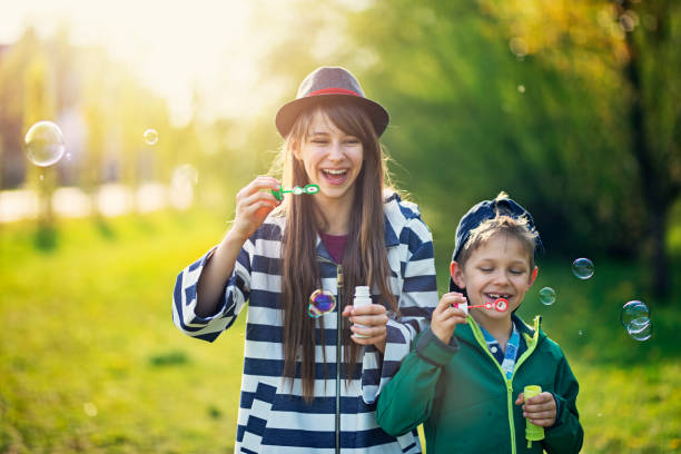 istock Brother and sister blowing bubbles on Spring day 1091665588