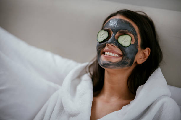 women holding slices of cucumber - facial mask spa treatment cucumber human face imagens e fotografias de stock