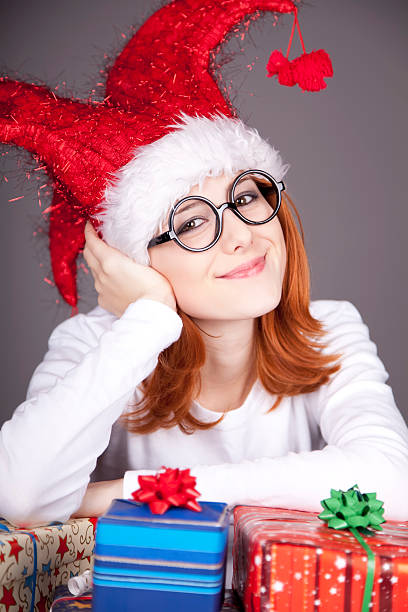istock Girl in christmas cap and glasses with gift boxes. 109167075