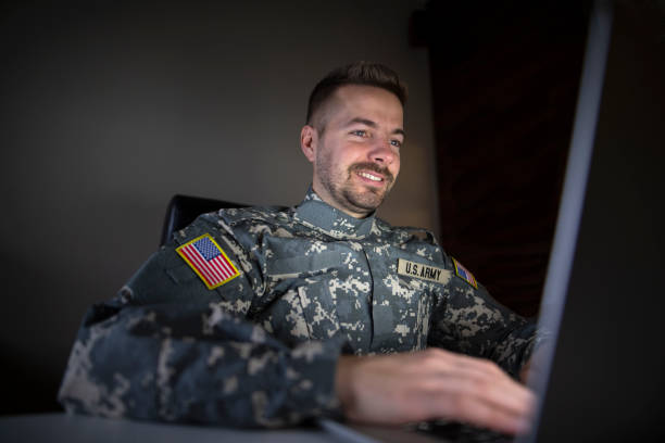istock Smiling Caucasian American soldier with USA patch flag using laptop computer. 1091673582