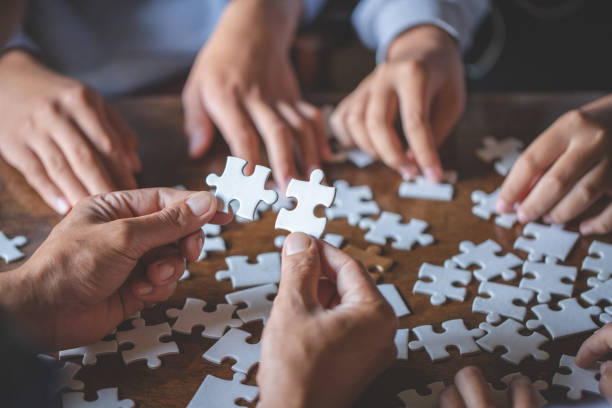 istock Hands of diverse people assembling jigsaw puzzle, team put pieces together searching for right match, help support in teamwork to find common solution concept, top close up view 1091674492