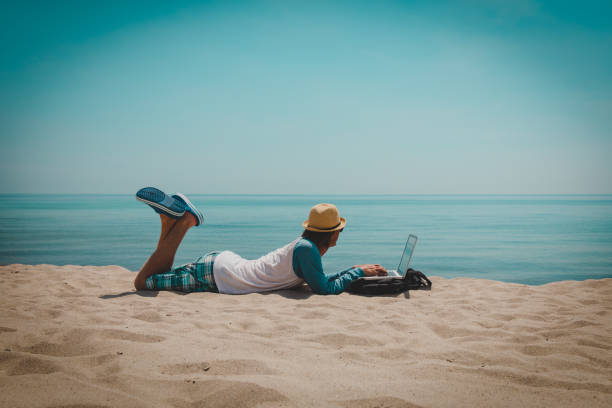 istock young man working on laptop at beach 1091674906